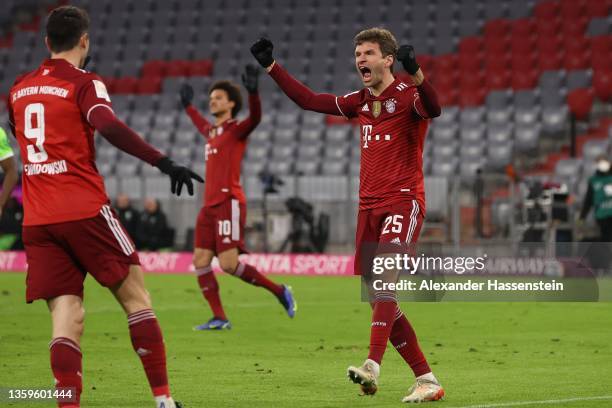 Thomas Mueller of Muenchen celebrates his team's first goal with teammate Robert Lewandowski during the Bundesliga match between FC Bayern München...