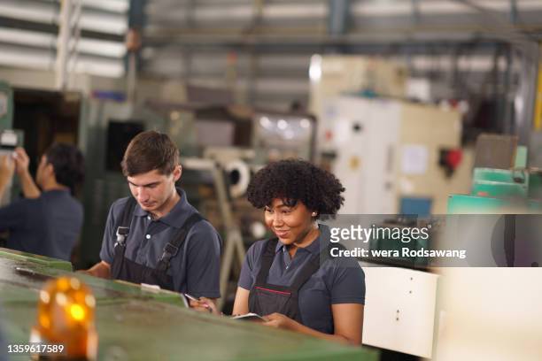 factory workers cooperate working in manufacturing factories machine part - production line worker stock pictures, royalty-free photos & images