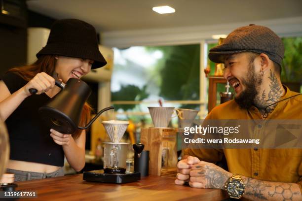 barista woman drip brewing coffee to client on coffee bar - barista coffee restaurant stockfoto's en -beelden