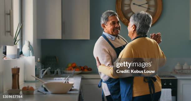 foto de una feliz pareja de ancianos bailando mientras prepara una comida en casa - couples making passionate love fotografías e imágenes de stock