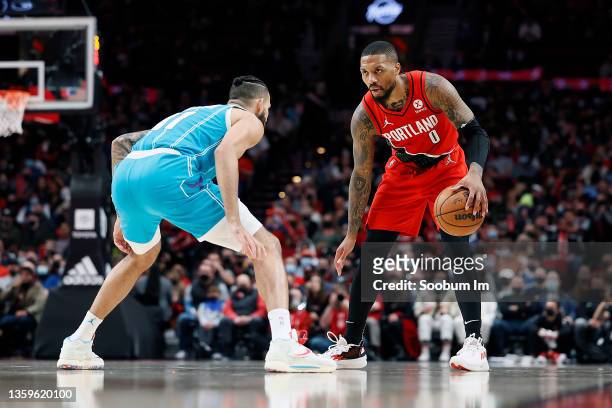 Damian Lillard of the Portland Trail Blazers dribbles the ball while defended by Cody Martin of the Charlotte Hornets during the first half at Moda...
