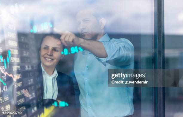 busines couple watching stock market data on a modern interface - screen dashboard analytics stockfoto's en -beelden