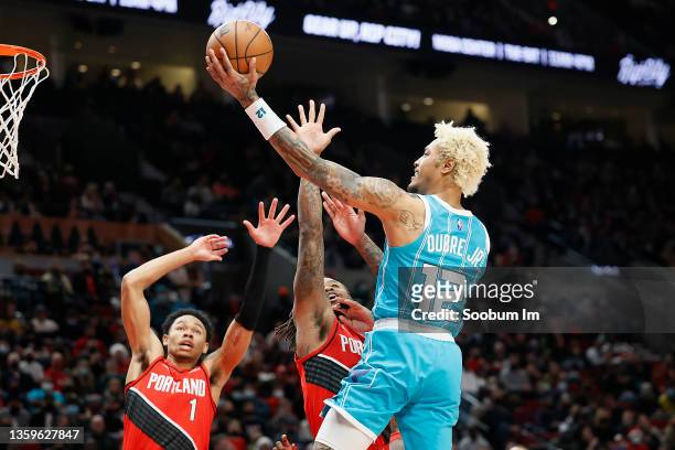 Kelly Oubre Jr. # 12 of the Charlotte Hornets shoots under pressure from Ben McLemore of the Portland Trail Blazers during the second half at Moda...