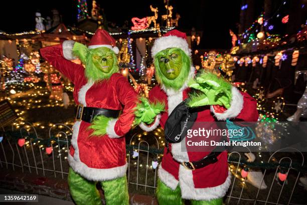 Cosplayers Gracie Bautista and Daniel Sanchez as Mr. And Mrs. Grinch pose for photos at Christmas on Knob Hill on December 17, 2021 in San Marcos,...