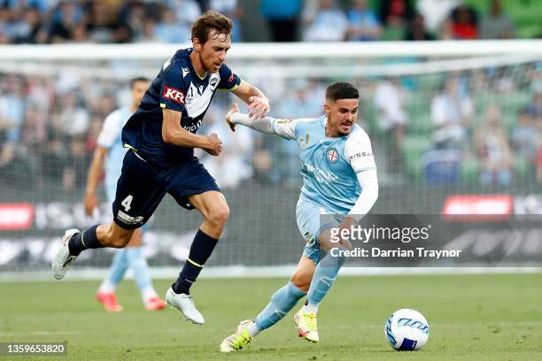 Marco Tilio of Melbourne City runs with the ball as Rai Marchan of Melbourne Victory applies pressure during the A-League mens match between...