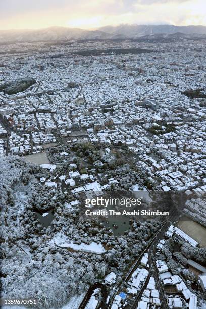 In this aerial image, Kinkakuji Temple and surrounding area are covered with snow on December 18, 2021 in Kyoto, Japan.