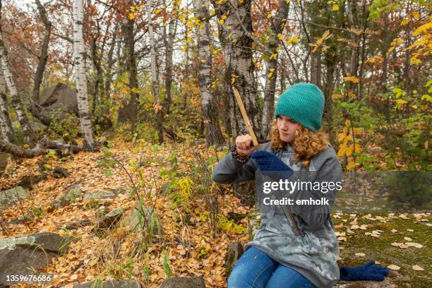 mädchen mit taschenmesser zum whittle stick in autumn woods - schnitzen stock-fotos und bilder