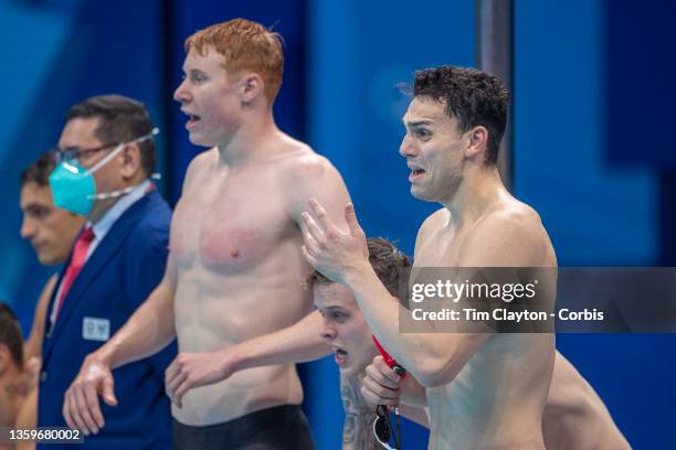 James Guy of Great Britain is overcome with emotion as team mates, Tom Dean and Matthew Richards watch Duncan Scott swimming the last leg during...