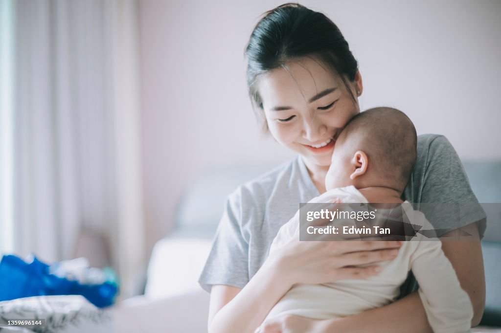 Asiatisch-chinesische Mutter, die sich mit ihrem kleinen Jungen zu Hause verbindet