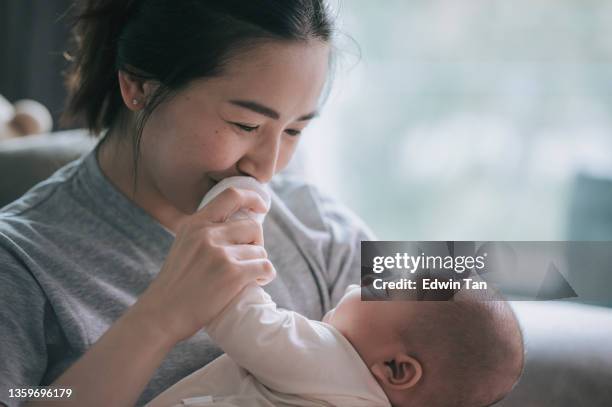 asiatisch-chinesische mutter, die sich mit ihrem kleinen jungen zu hause verbindet - chinese family taking photo at home stock-fotos und bilder
