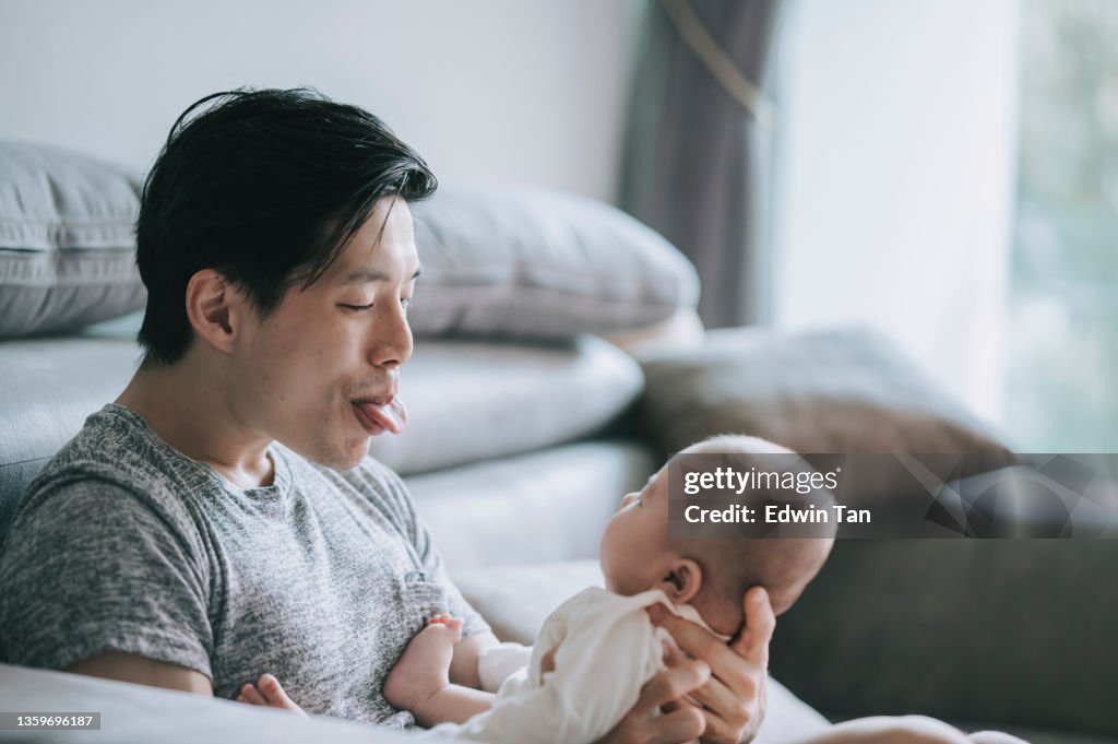 Asian Chinese young father bonding time playing with his baby boy son at living room during weekend