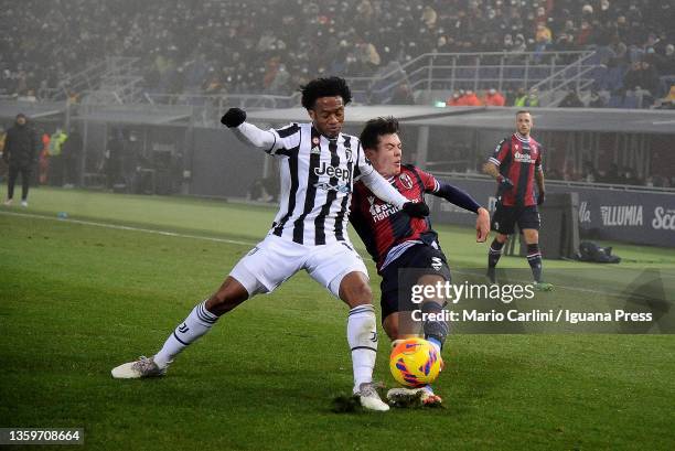 Juan Cuadrado of Juventus competes the ball with Aaron Hickey of Bologna FC during the Serie A match between Bologna FC and Juventus at Stadio Renato...