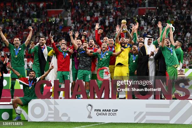 Rais Mbolhi of Algeria lifts the FIFA Arab Cup trophy following victory during the FIFA Arab Cup Qatar 2021 Final match between Tunisia and Algeria...
