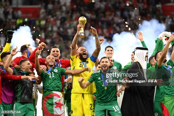 Rais Mbolhi of Algeria lifts the FIFA Arab Cup trophy following victory during the FIFA Arab Cup Qatar 2021 Final match between Tunisia and Algeria...