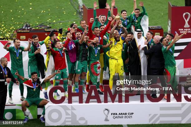 Rais Mbolhi of Algeria lifts the FIFA Arab Cup trophy following victory during the FIFA Arab Cup Qatar 2021 Final match between Tunisia and Algeria...