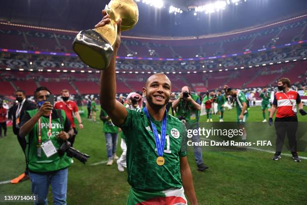 Yacine Brahimi of Algeria celebrates with the FIFA Arab Cup trophy following victory during the FIFA Arab Cup Qatar 2021 Final match between Tunisia...
