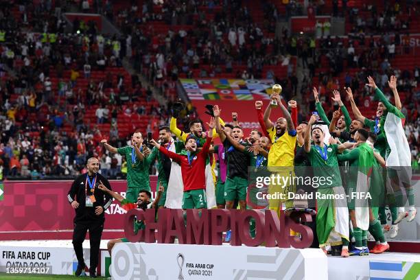 Rais Mbolhi of Algeria lifts the FIFA Arab Cup trophy following victory during the FIFA Arab Cup Qatar 2021 Final match between Tunisia and Algeria...