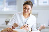 Female dermatologist performing a procedure on a client