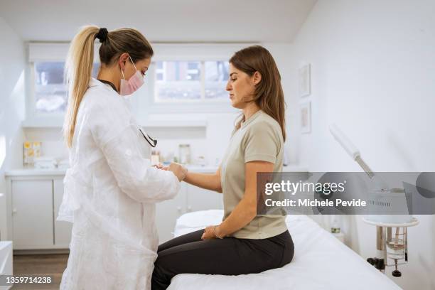 female doctor performing a physical examination on the client - showus doctor stock pictures, royalty-free photos & images