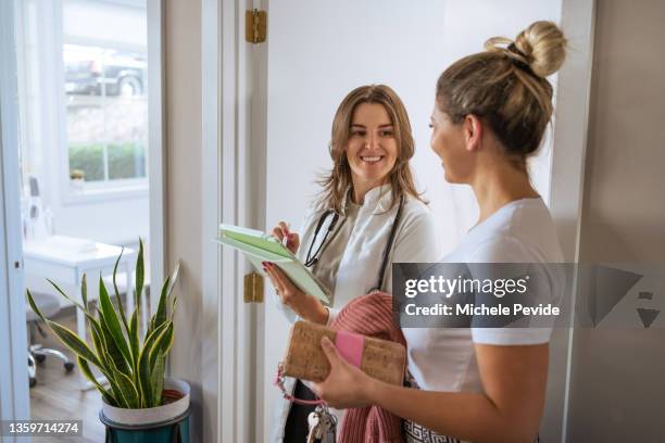 female doctor  holding an ipad and talking with a client - showus doctor stock pictures, royalty-free photos & images