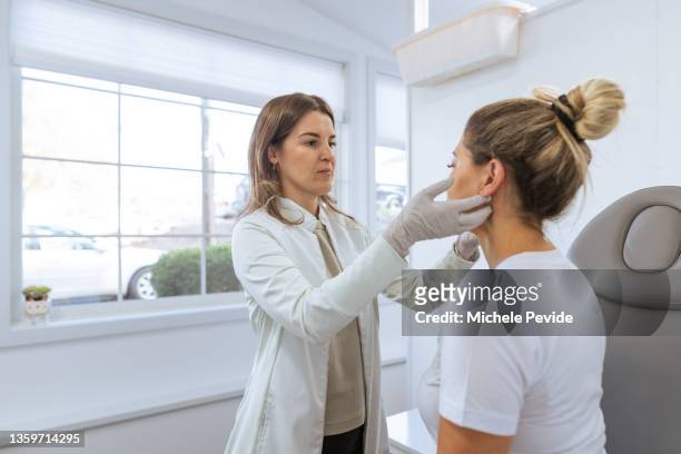 female dermatologist performing a procedure on a client - showus doctor stock pictures, royalty-free photos & images