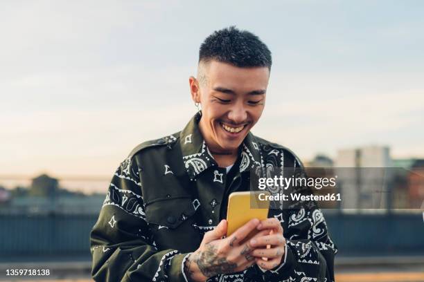 happy hipster man using smart phone at street - young men smiling stock pictures, royalty-free photos & images