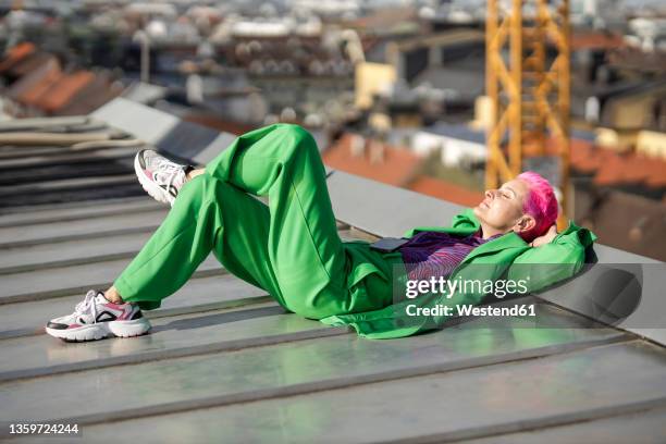 businesswoman with hands behind head sleeping on rooftop - woman 45 sleeping stock pictures, royalty-free photos & images