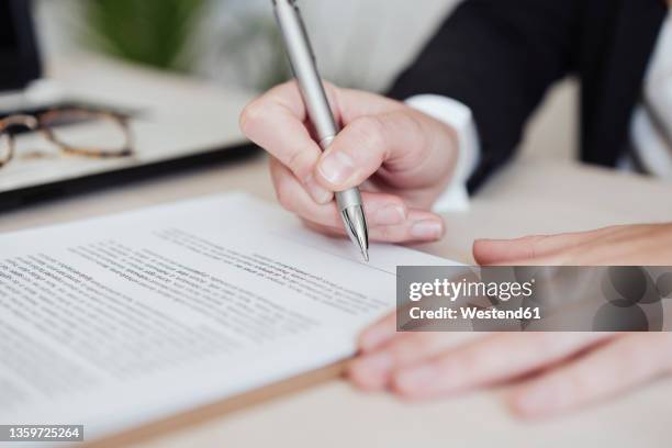 real estate agent signing document at office - legal document stock pictures, royalty-free photos & images