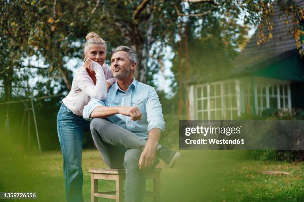 thoughtful woman leaning on man at backyard - house front bildbanksfoton och bilder