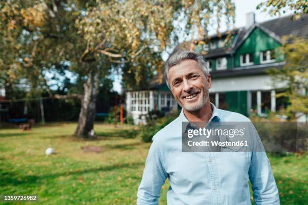 smiling man standing at backyard - front or back yard - fotografias e filmes do acervo