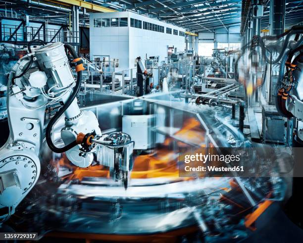 robotic arms operating inside modern factory - robotics stock pictures, royalty-free photos & images