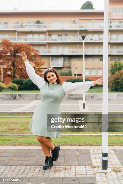 cheerful plus size woman dancing on footpath - fat woman dancing stockfoto's en -beelden