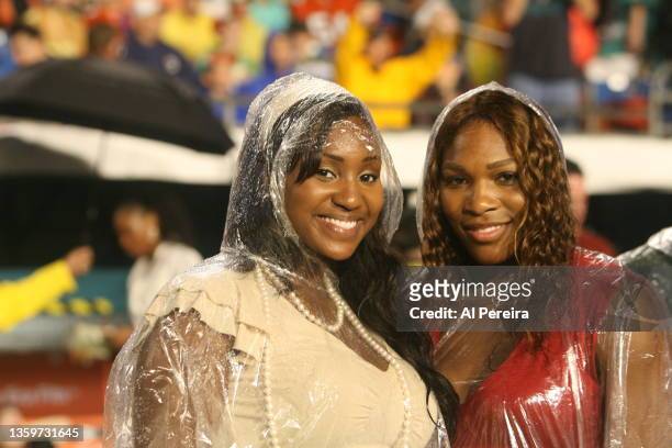Serena Williams and her half sister, Isha Price, appear in the rain on Christmas night on the sidelines of the New York Jets vs Miami Dolphins game...