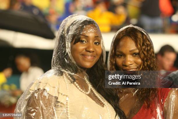 Serena Williams and her half sister, Isha Price, appear in the rain on Christmas night on the sidelines of the New York Jets vs Miami Dolphins game...
