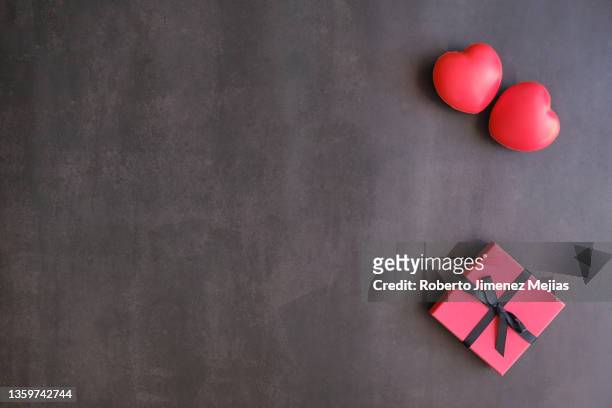 corazones y caja de regalo sobre fondo oscuro - caja de regalo stockfoto's en -beelden