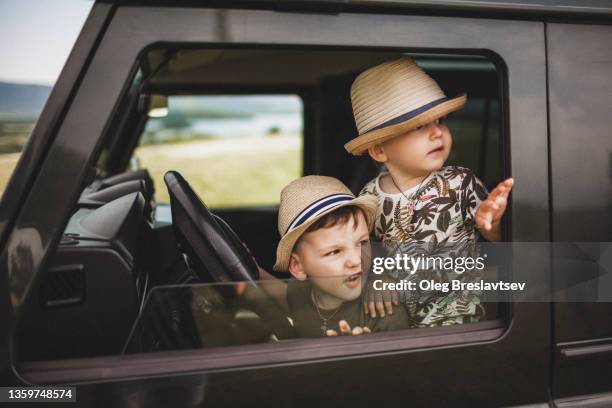 children having fun in car behind the wheel. two brothers - children funny moments stock pictures, royalty-free photos & images