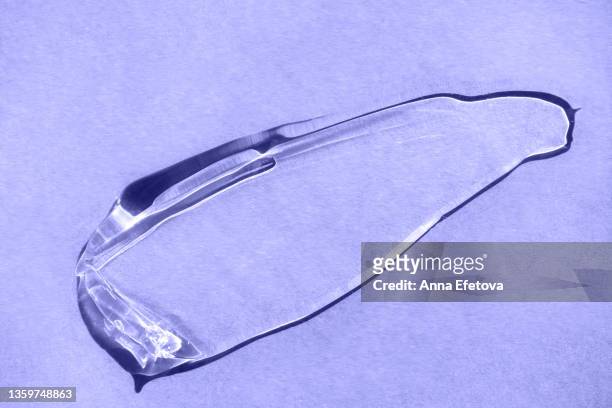 blot of transparent cosmetic gel for skin care procedures smeared on pastel violet background. photography in flat lay style. polyglutamic acid. demonstrating very peri - color of 2022 year - grease imagens e fotografias de stock