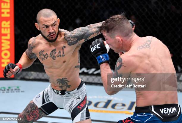 Cub Swanson punches Darren Elkins in their featherweight fight during the UFC Fight Night event at UFC APEX on December 18, 2021 in Las Vegas, Nevada.