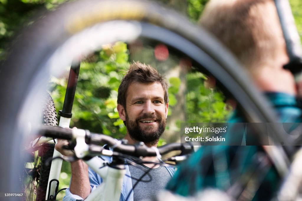 Man holding mountainbike over shoulder