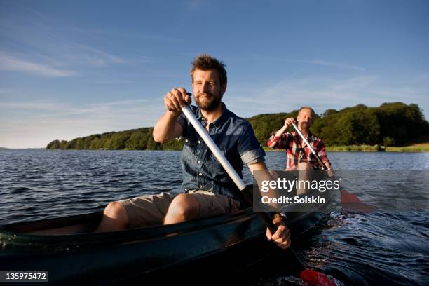 friends sitting in canoe - kanoën stockfoto's en -beelden