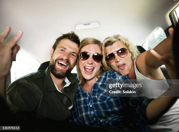 three friends sitting in car, having fun - 3 guy friends road trip stock pictures, royalty-free photos & images