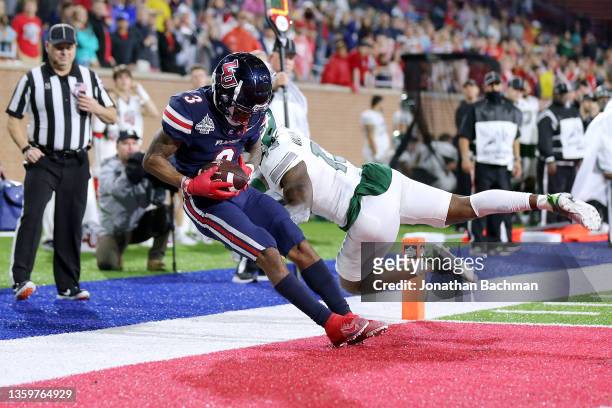 Demario Douglas of the Liberty Flames scores a touchdown as Russell Vaden IV of the Eastern Michigan Eagles defends during the second half of the...