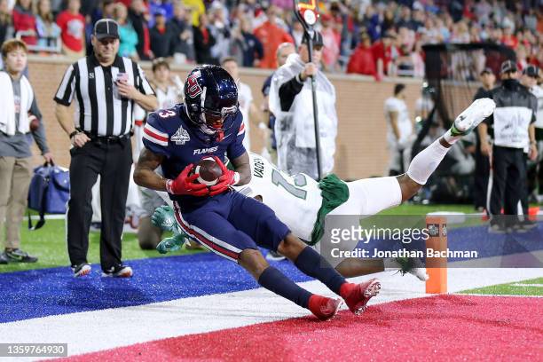 Demario Douglas of the Liberty Flames scores a touchdown as Russell Vaden IV of the Eastern Michigan Eagles defends during the second half of the...