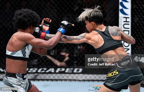 Amanda Lemos of Brazil punches Angela Hill in their bantamweight fight during the UFC Fight Night event at UFC APEX on December 18, 2021 in Las...