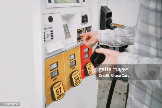 man purchases gas at pump - zapfsäule stock-fotos und bilder