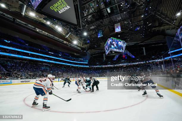 Connor McDavid of the Edmonton Oilers and Marcus Johansson of the Seattle Kraken face-off during the first period of a game between the Edmonton...