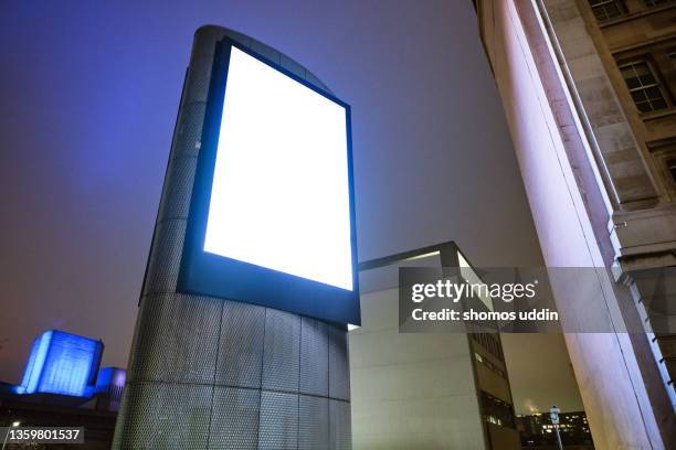 low angle view of blank electronic billboard at night - billboard night stock pictures, royalty-free photos & images