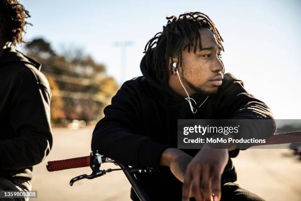 portrait of young male bmx riders in urban area - hoodie headphones - fotografias e filmes do acervo
