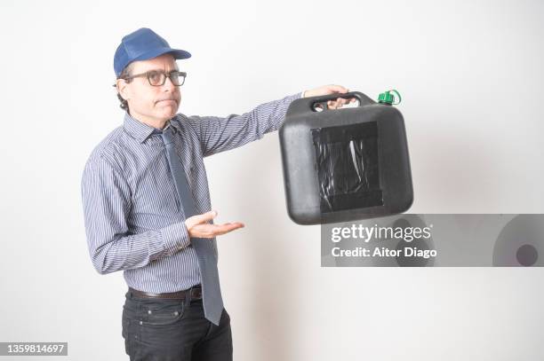 business man holds a jerry can of petrol in his hand. there is a problem: the prices are vey high. - energy tariff stock pictures, royalty-free photos & images