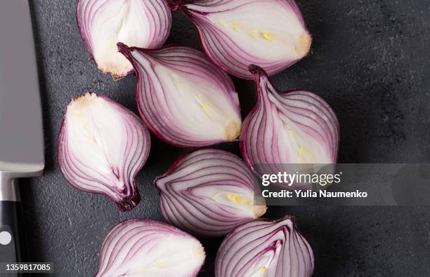 fresh red onions on a black table. halves of onions. - cutting red onion stock pictures, royalty-free photos & images